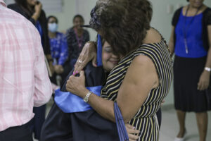 Madre abraza hija graduada