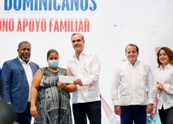 Presidente entrega cheque a beneficiaria bono familiar