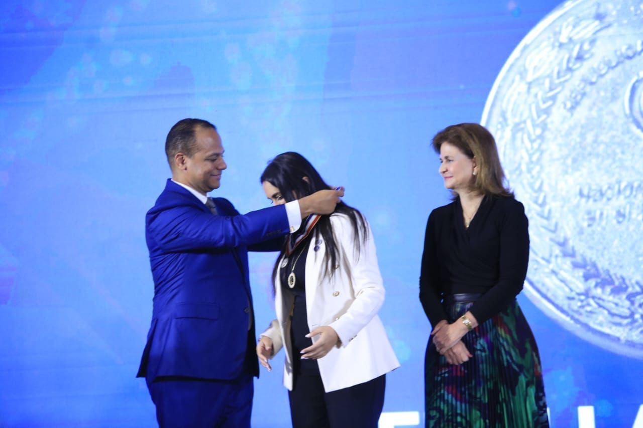 Carolina Serrata recibe mientras recibe la medalla junto a la vicepresidenta de la República Dominicana