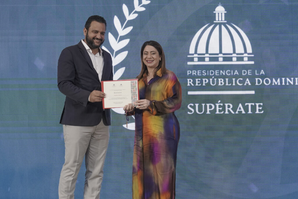 Foto de la Directora de Supérate, Gloria reyes, recibiendo reconocimiento