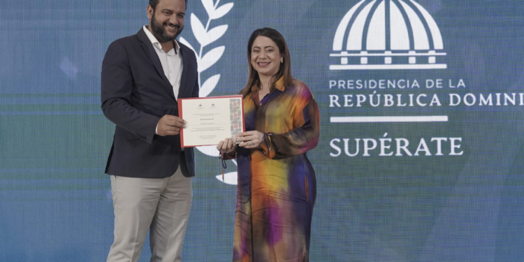 Foto de la Directora de Supérate, Gloria reyes, recibiendo reconocimiento