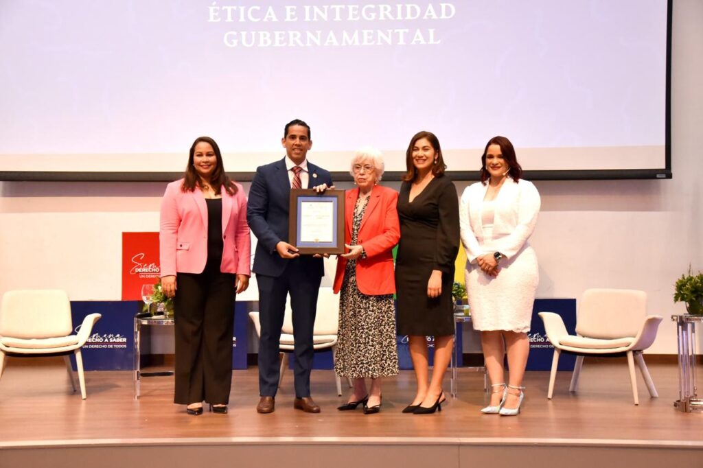 Fotografía Edward Guzmán recibe el reconocimiento de manos de la propia Milagros Ortíz Bosch, Directora General de la DIGEIG