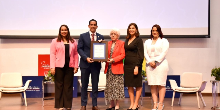 Fotografía Edward Guzmán recibe el reconocimiento de manos de la propia Milagros Ortíz Bosch, Directora General de la DIGEIG