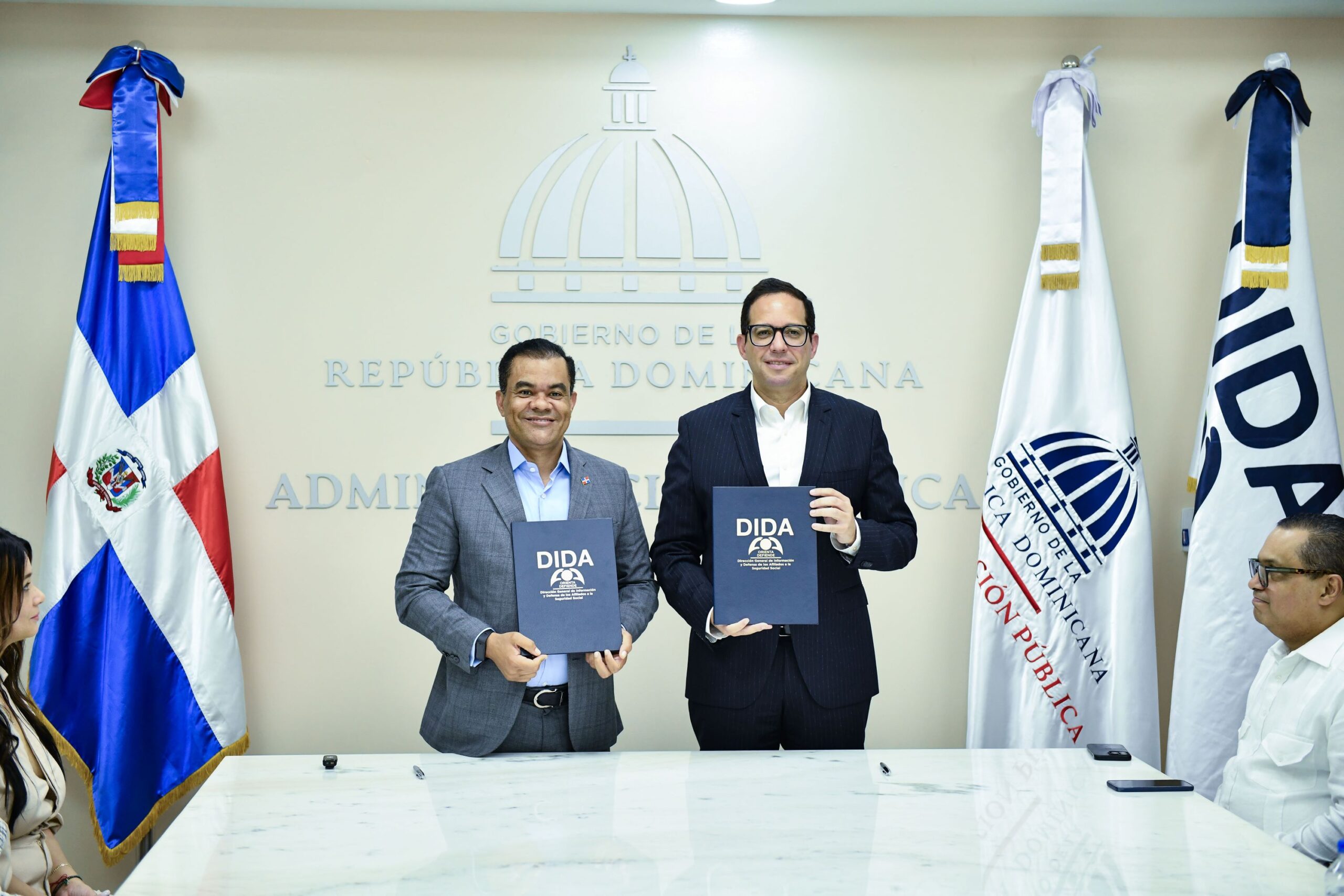 El director general de la DIDA, Elías Báez y Sigmund Freund, Ministro de Administración Pública, muestra la normativa conjunta emitida y que permitirá a los servidores públicos aprovechar mejor sus derechos en eguridad social. (LaSeguridadSocial.Do)